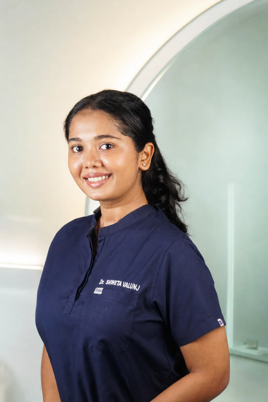 Dr. Shweta Valunj in navy dental scrubs